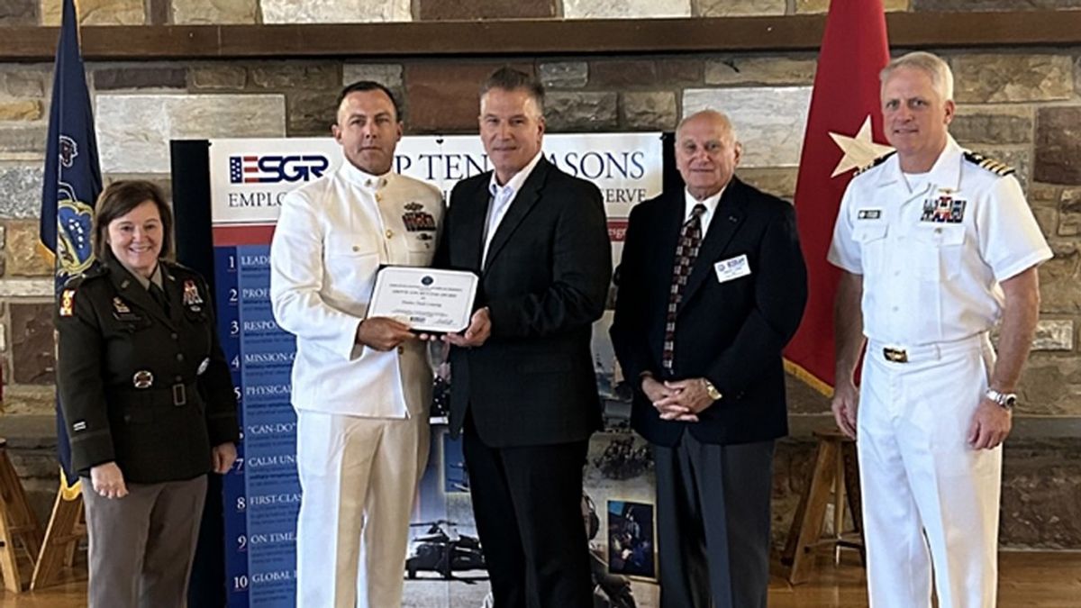 Five people standing together displaying an award.